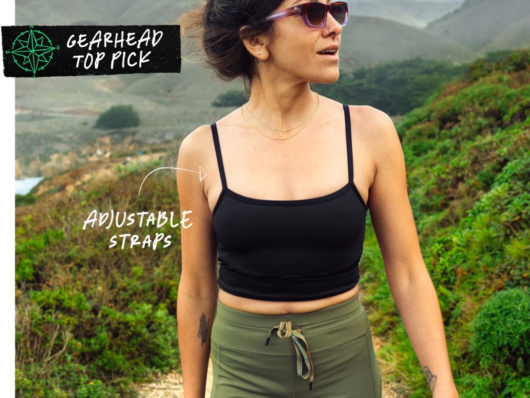A woman walks on a trail near the ocean. Text overlay reads: Gearhead top pick, adjustable straps.